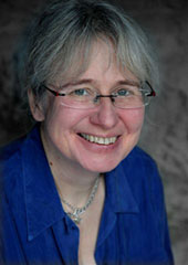 Sue Tompkins smiling, wearing a blue scarf